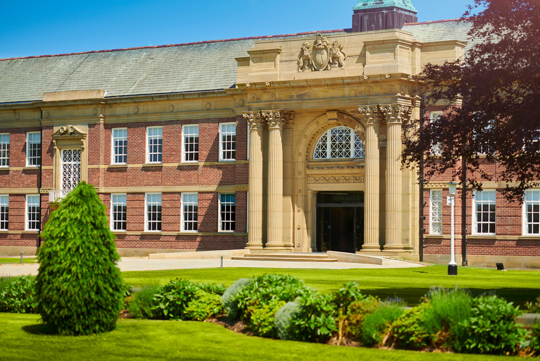 Photo image of Edge Hill University main building. Gardens and planting are in front of the building.